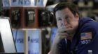 Specialist Gregg Maloney works at his post on the floor of the New York Stock Exchange Friday, Aug. 12, 2011. A wild week end