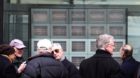 Some passer-bys follow the stock exchange on several screens outside the UBS Bank on the Bahnhofstrasse in Zurich, Switzerlan