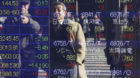 People are reflected on the electronic board of a securities firm in Tokyo Thursday, Dec. 13, 2012. Asian stock markets rose