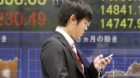 A man walks by an electronic stock board of a securities firm in Tokyo, Monday, May 13, 2013. Japan's stock market jumped Mon