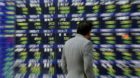 epa03713029 A pedestrian is watching an electric quotation board displaying Tokyo stock index in Tokyo, Japan, 23 May 2013.