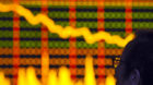 A stock investor looks at a board showing stock index at a brokerage house in Hefei, in central China's Anhui province, Tuesd