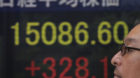 A man walks by the electronic stock board of a securities firm in Tokyo, Wednesday, May 15, 2013. Enthusiasm on Wall Street s