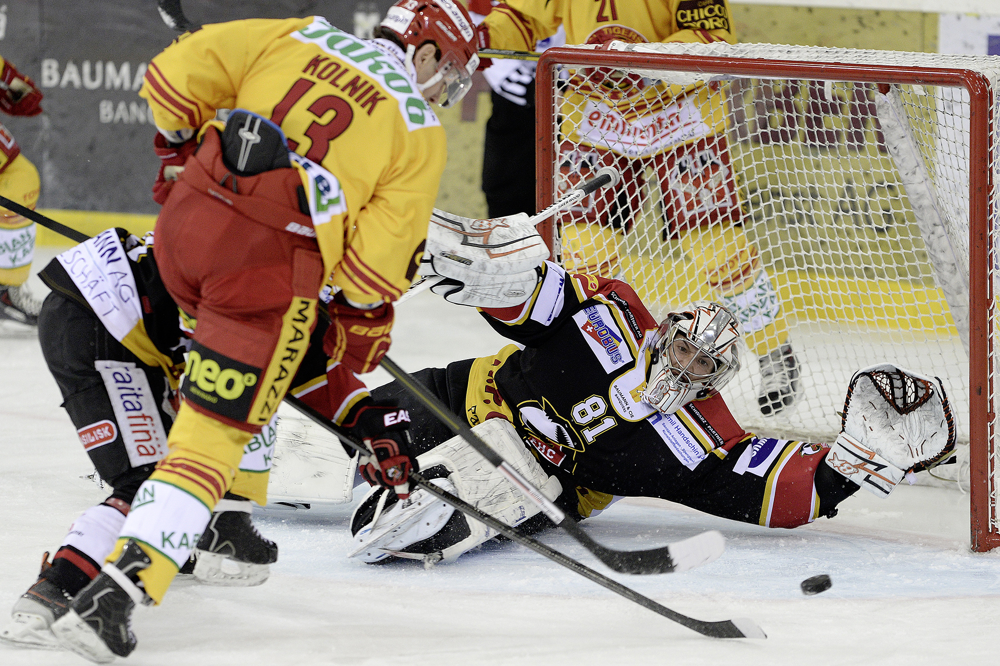 Der Basler Torhueter Urban Leimbacher, rechts, pariert einen Schuss von Langnauer Juraj Kolnik, links, beim Spiel der National League B zwischen den EHC Basel Sharks und den SCL Tigers in der St. Jakob-Arena in Basel am Donnerstag, 12. Dezember 2013. (KEY