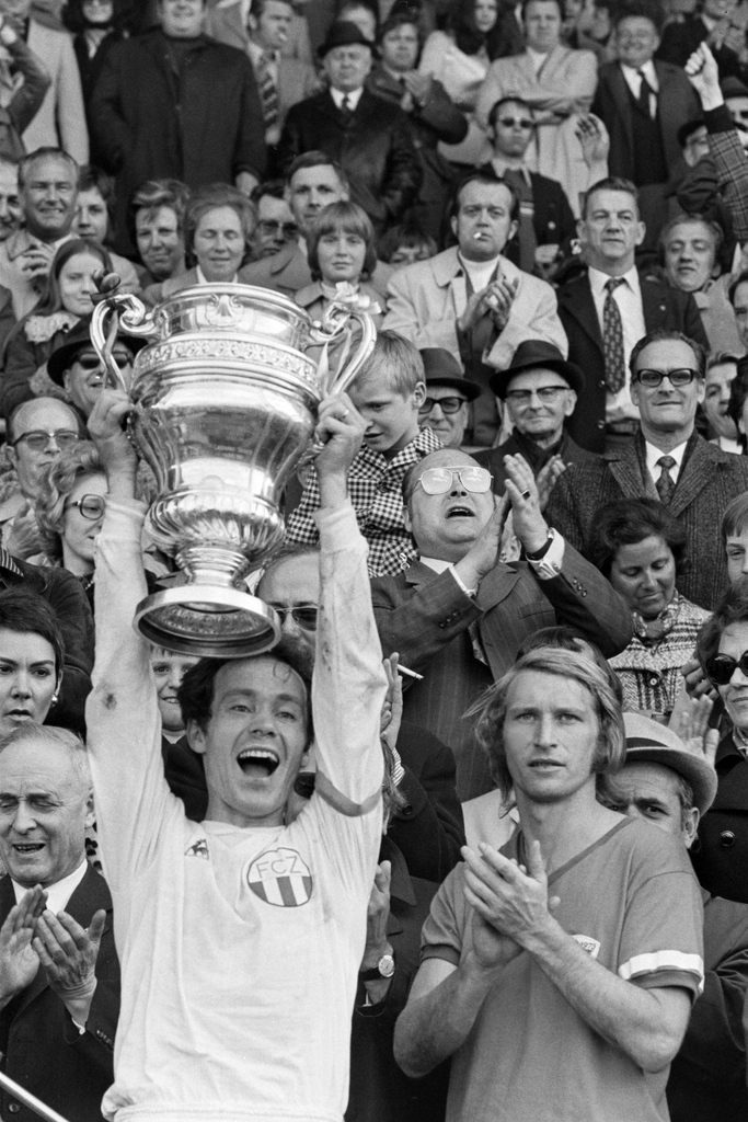 Aller guten Dinge sind drei: FCZ-Captain Köbi Kuhn stemmt 1973 die Sandoz-Trophäe für den Schweizer Cupsieger. Karl Odermatt bleibt als FCB-Captain zum dritten Mal nur, zu applaudieren. (Bild: Keystone)