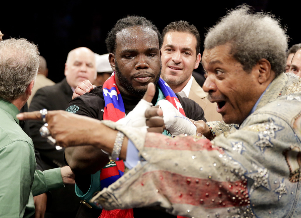 Bermane Stiverne, center, celebrates his win over Chris Arreola with promoter Don King after a rematch for the WBC heavyweight boxing title in Los Angeles, Saturday, May 10, 2014. ()