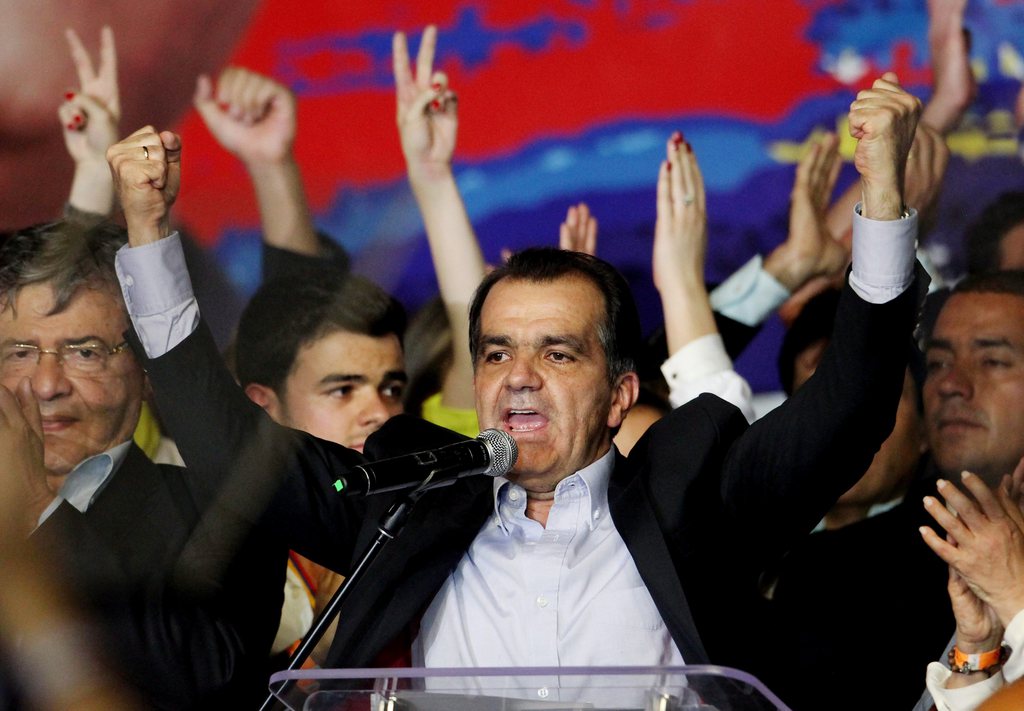 epa04225861 Colombian presidential candidate for the Democratic Center Party, Oscar Ivan Zuluaga (C) delivers a speech to supporters in Bogota, Colombia, 25 May 2014. Zuluaga won with a 29.25 percent in the first round of the Colombian presidential electi