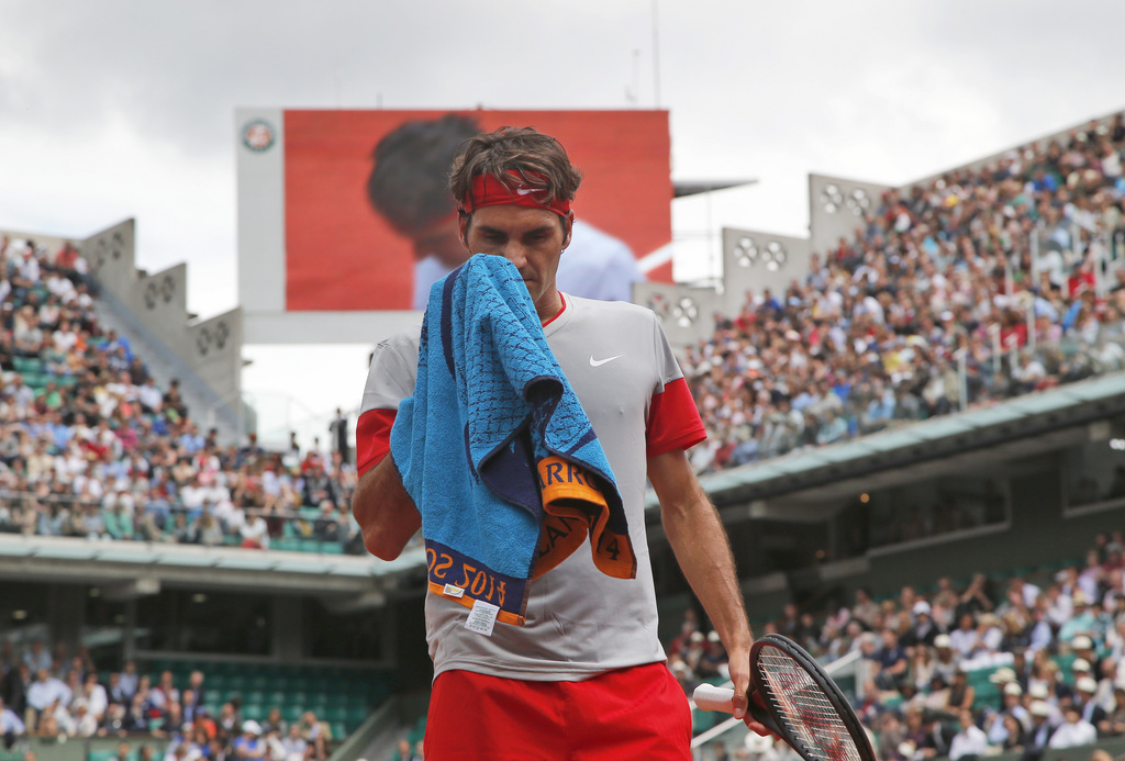 Switzerland's Roger Federer wipes his face during the third round match of the French Open tennis tournament against Russia's Dmitry Tursunov at the Roland Garros stadium, in Paris, France, Friday, May 30, 2014. (AP Photo/Michel Euler)
