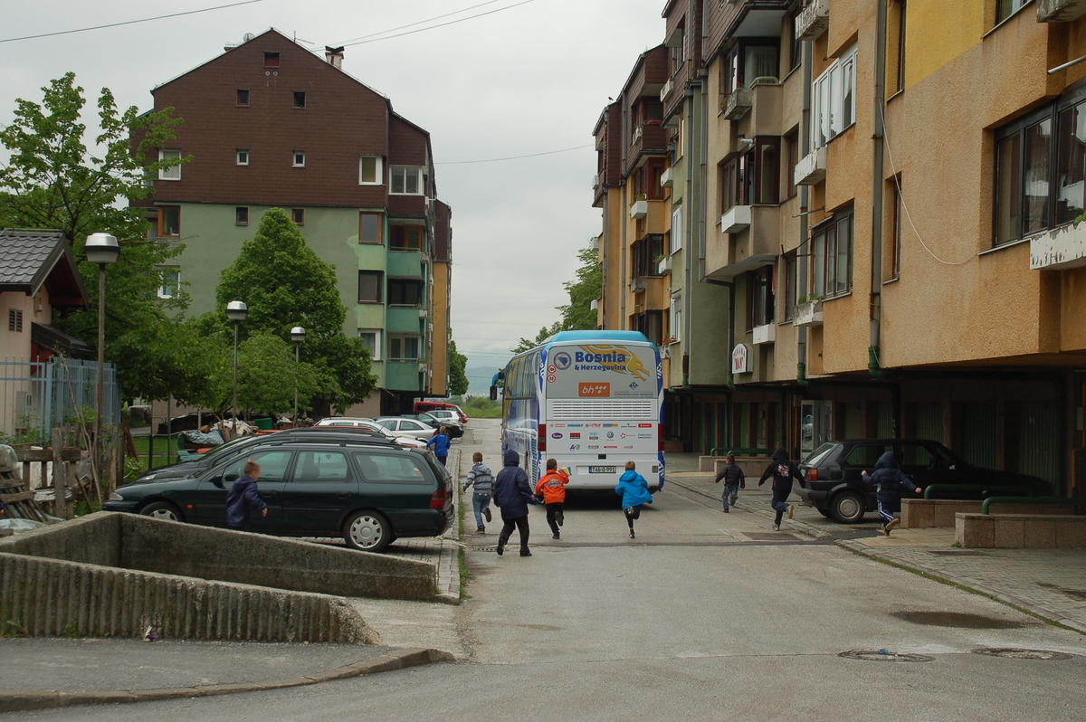 Kinder laufen dem Bus der Nationalmannschaft nach dem Training im Stadion Hrasnica hinterher.
