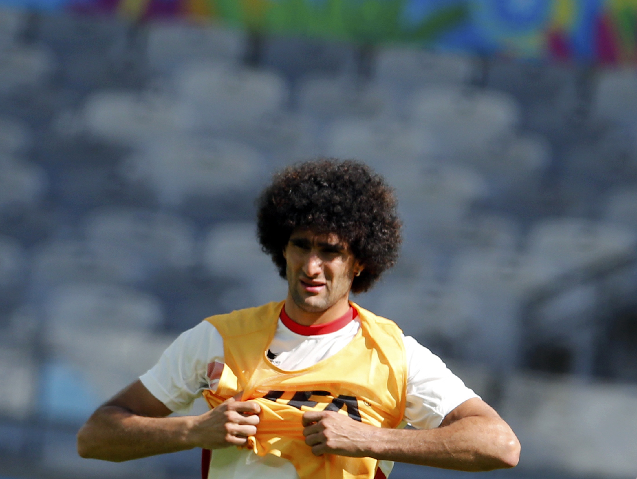 Belgium's national soccer team player Marouane Fellaini puts on a vest as he attends a training session at the Mineirao stadium in Belo Horizonte June 16, 2014. Belgium will face Algeria in their first 2014 World Cup Group H soccer match on June 17. REUTE