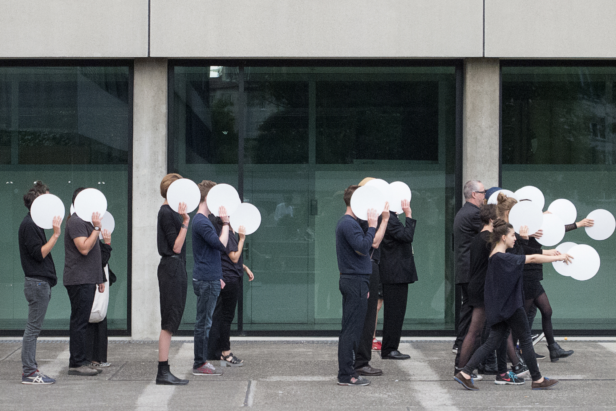 So war die Performance gedacht: Schwarz gekleidete Studenten marschieren in Polizeiformation.