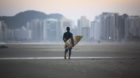 epa04255691 A Brazilian surfer walks along a beach in Guaruja, Sao Paulo, Brazil 13 June 2014. Sao Paulo is one of the host c