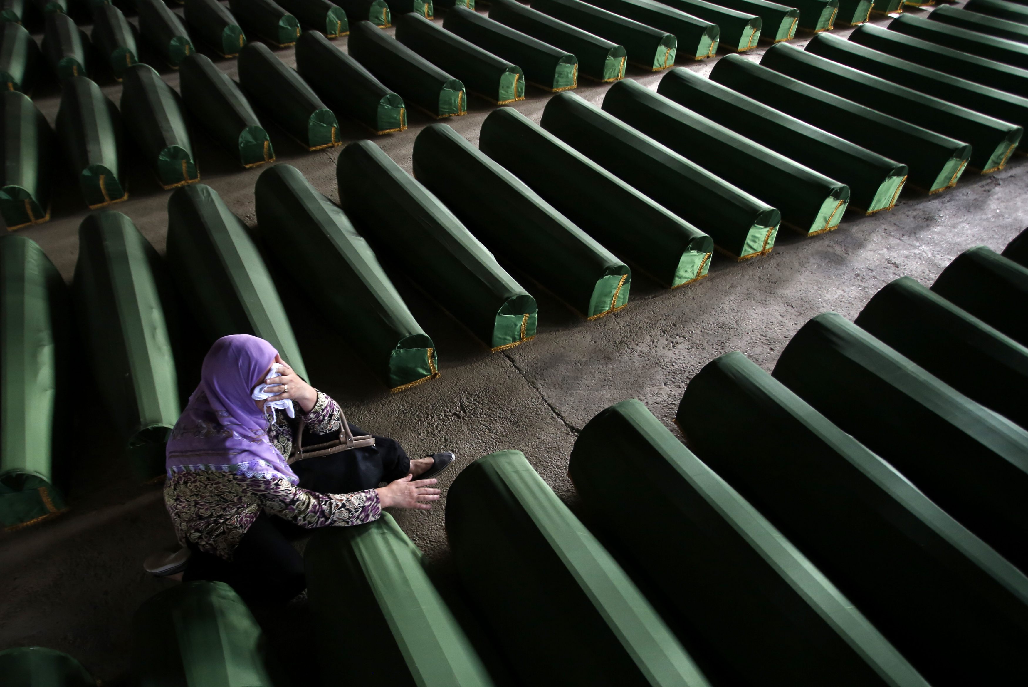 A Bosnian Muslim woman cries near coffin of a relative, which is one of the 175 coffins of newly identified victims from the 1995 Srebrenica massacre, in Potocari Memorial Center, near Srebrenica, July 10, 2014. Family members, foreign dignitaries and gue