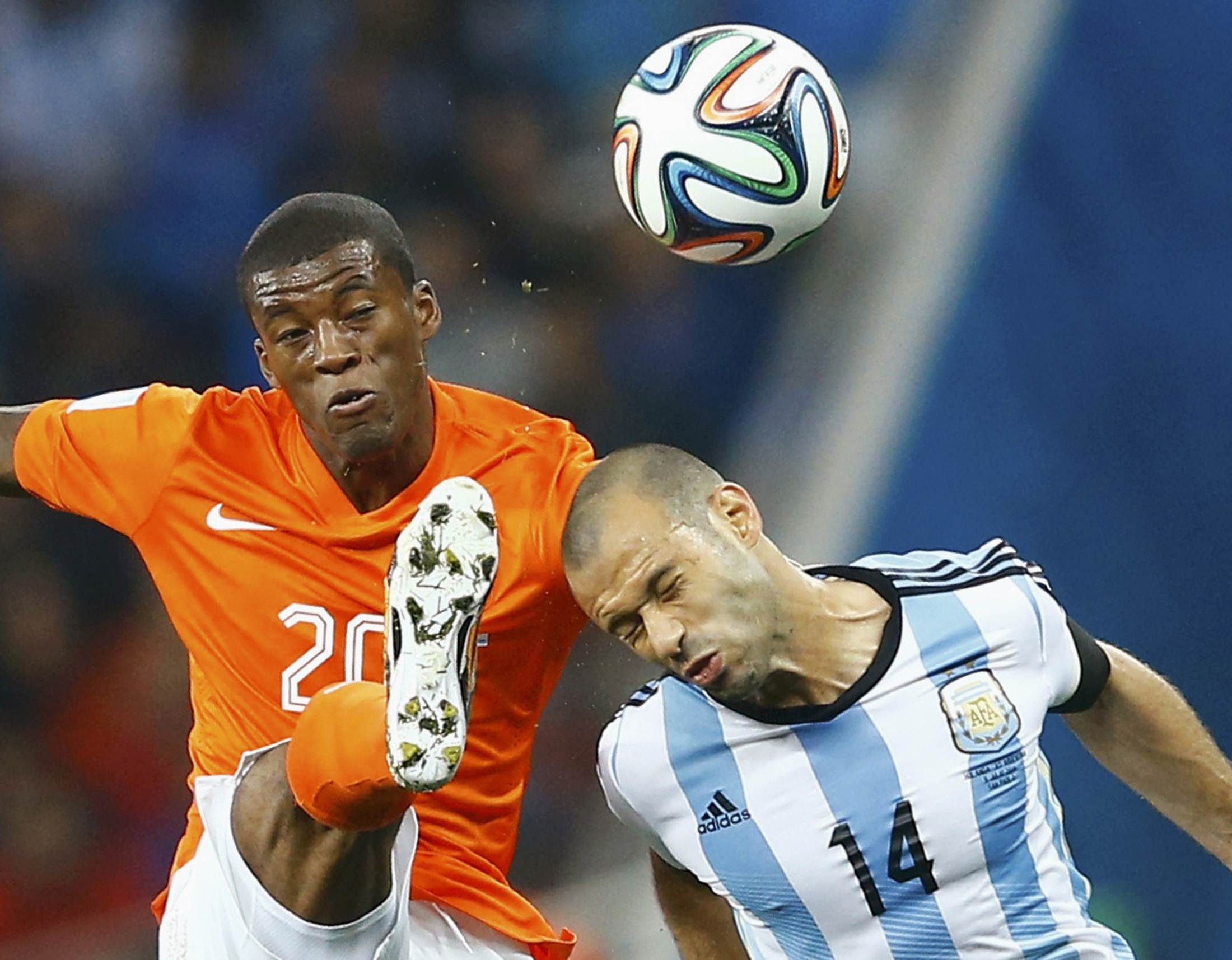 Georginio Wijnaldum of the Netherlands kicks the ball beside Argentina's Javier Mascherano (R) during their 2014 World Cup semi-finals at the Corinthians arena in Sao Paulo July 9, 2014.  REUTERS/Dominic Ebenbichler (BRAZIL  - Tags: SOCCER SPORT WORLD CUP