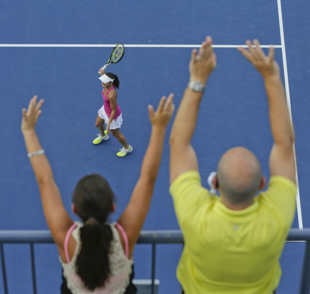 Spectators cheer as Martina Hingis, of Switzerland, prepares to hit autographed balls into the crowd after winning a doubles match with Flavia Pennetta, of Italy, against Kveta Peschke and Katarina Srebotnik in the quarterfinals of the 2014 U.S. Open tenn