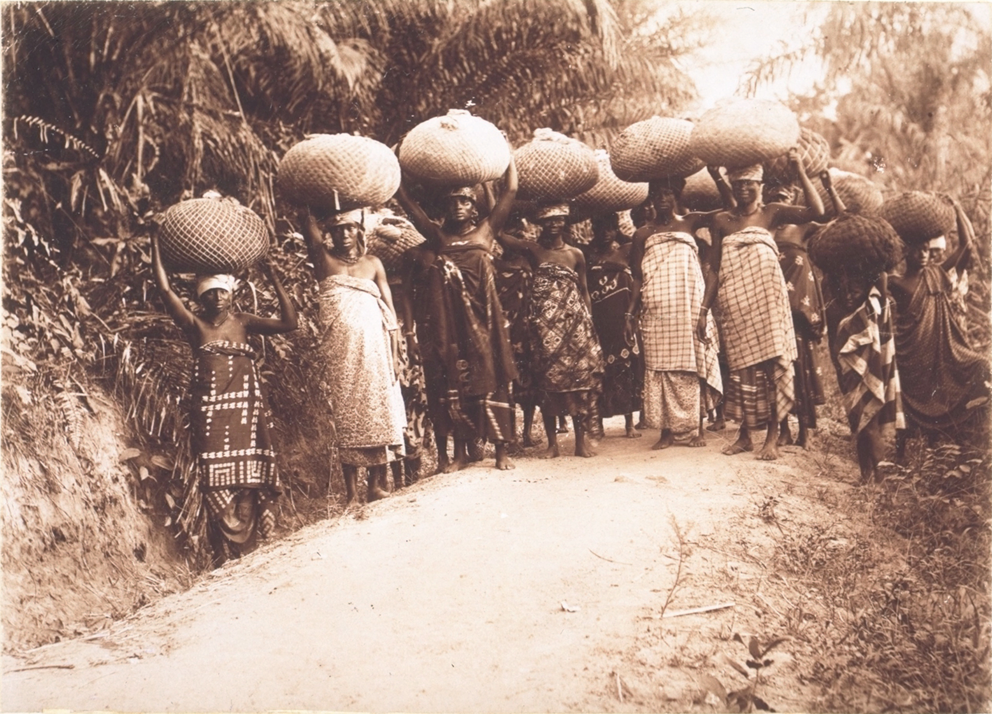 Frauen schleppen Kakaoballen zum Verlad an die Küste. Das Bild entstand zwischen 1900 und 1911.