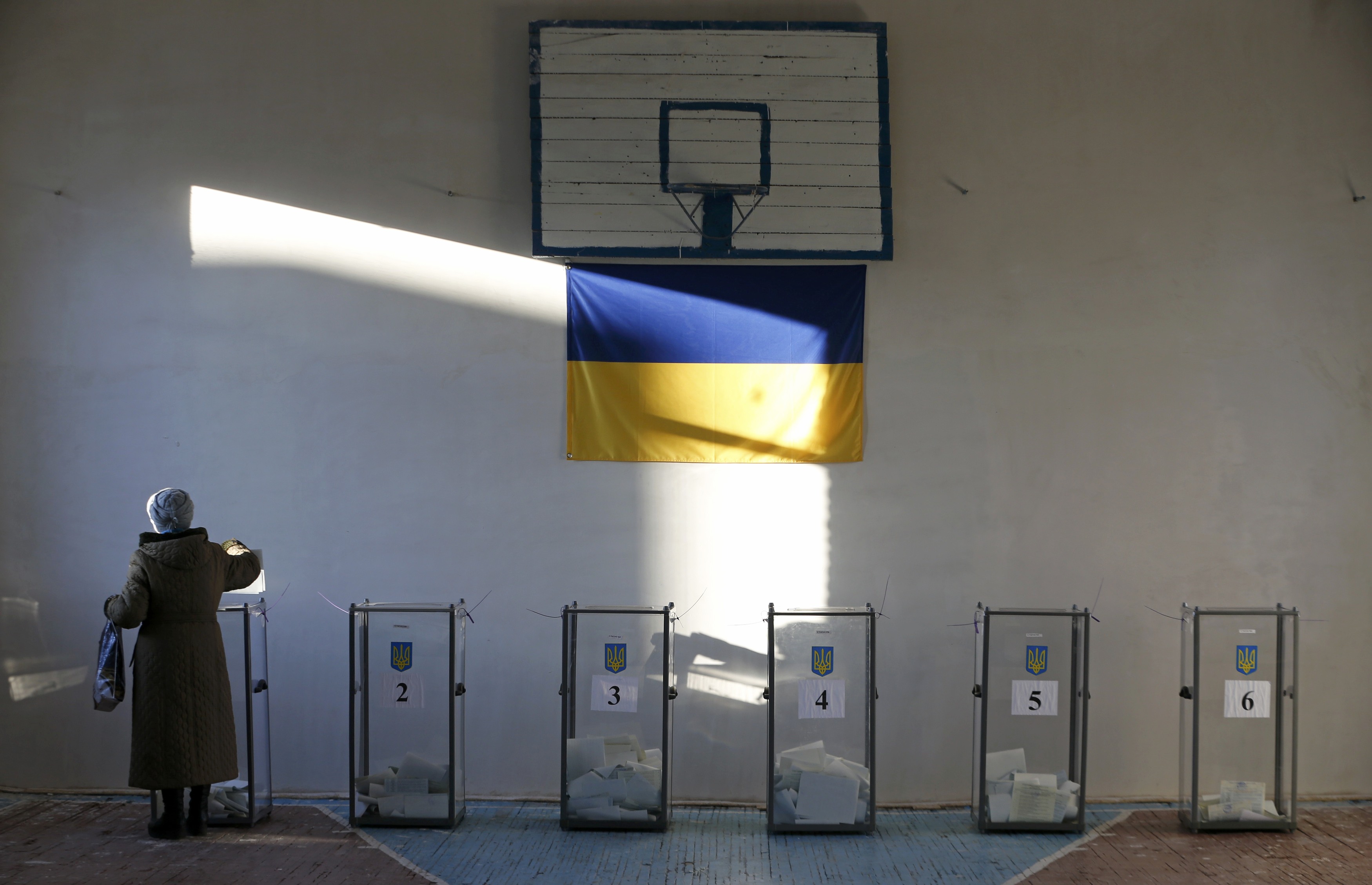 A woman casts a ballot during a parliamentary election at a school gym in the village of Semyonovka near Slaviansk, eastern Ukraine, October 26, 2014. Ukrainians voted on Sunday in an election that is likely to install a pro-Western parliament and strengthen President Petro Poroshenko's mandate to end separatist conflict in the east, but may fuel tension with Russia. REUTERS/Vasily Fedosenko (UKRAINE - Tags: POLITICS ELECTIONS TPX IMAGES OF THE DAY)