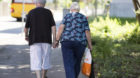 An elderly couple holds hands while walking on a street, pictured in Winterthur in the Canton of Zurich, Switzerland, on June