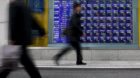 epa01659628 Japanese pedestrians walk by at Nikkei stock index board in downtown Tokyo, Japan 09 March 2009. Japanese stocks