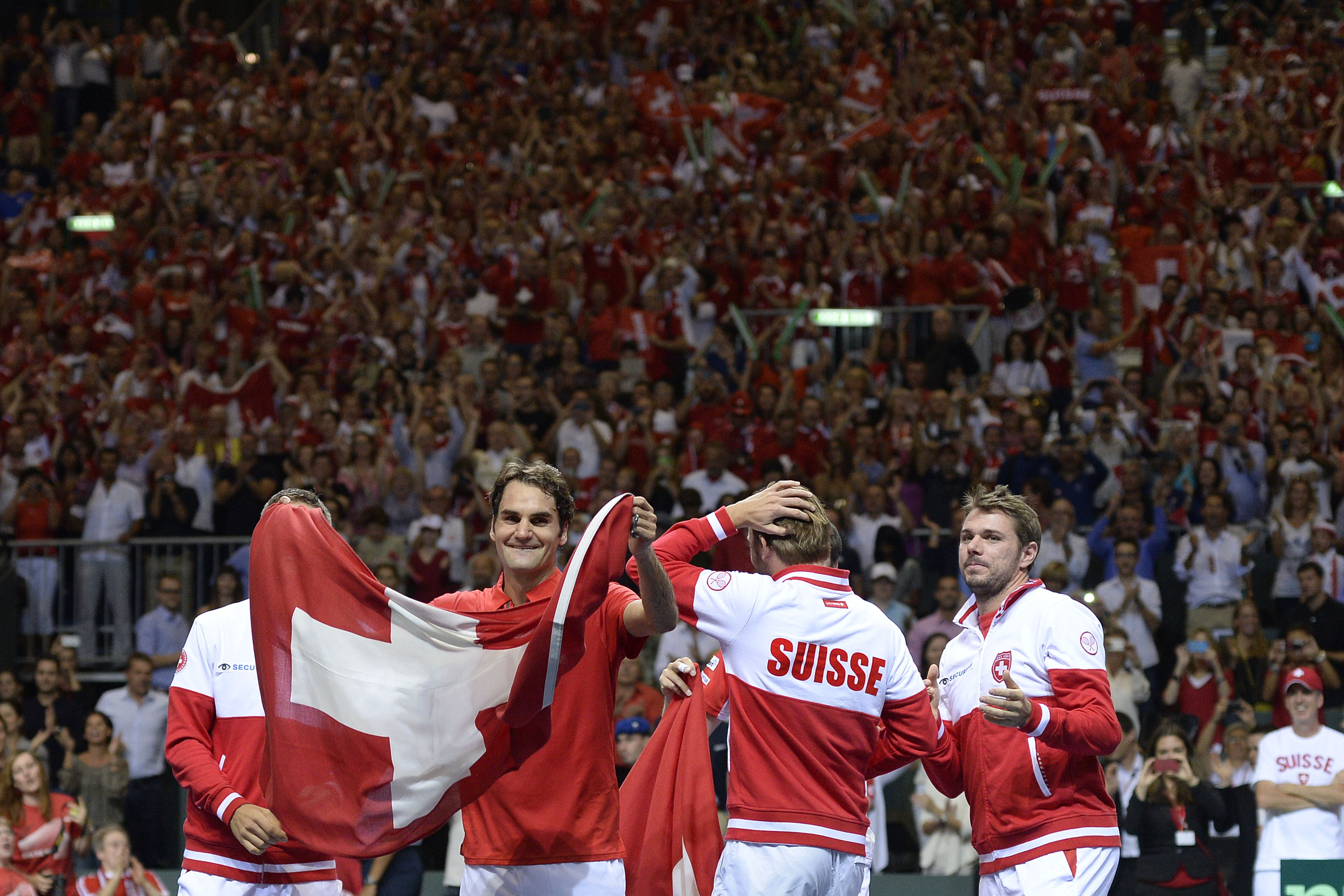 Im besten Fall fröhlicher Patriotismus: Die Schweiz gewinnt im Halbfinal von Genf gegen Italien. Roger Federer feiert mit Schweizerflagge und den Teamkollegen Marco Chiudinelli, Michael Lammer und Stan Wawrinka.