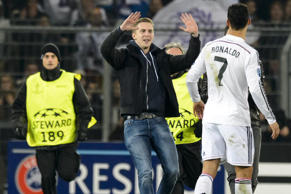 Fans run in the pitch next to Madrid�s Cristiano Ronaldo, right, during an UEFA Champions League group B matchday 5 soccer match between Switzerland's FC Basel 1893 and Spain's Real Madrid CF in the St. Jakob-Park stadium in Basel, Switzerland, on Wednesday, November 26, 2014. (KEYSTONE/Laurent Gillieron)