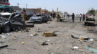 Civilians and security forces inspect the site of a suicide bomb attack in Tuz Khormato, 130 miles (210 kilometers) north of