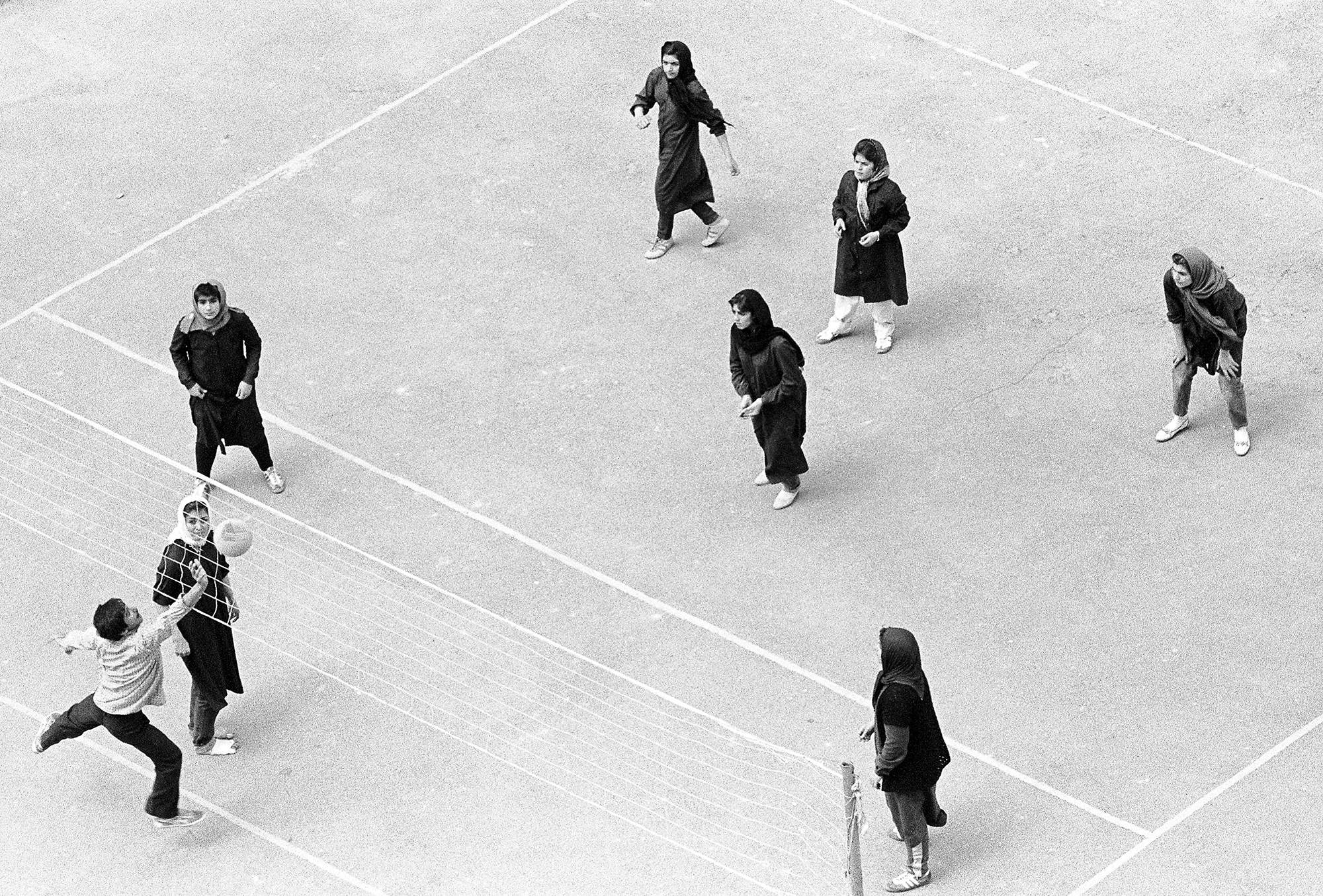 Teheran 1982: Junge Frauen im Schleier spielen gegen junge Männer Volleyball.