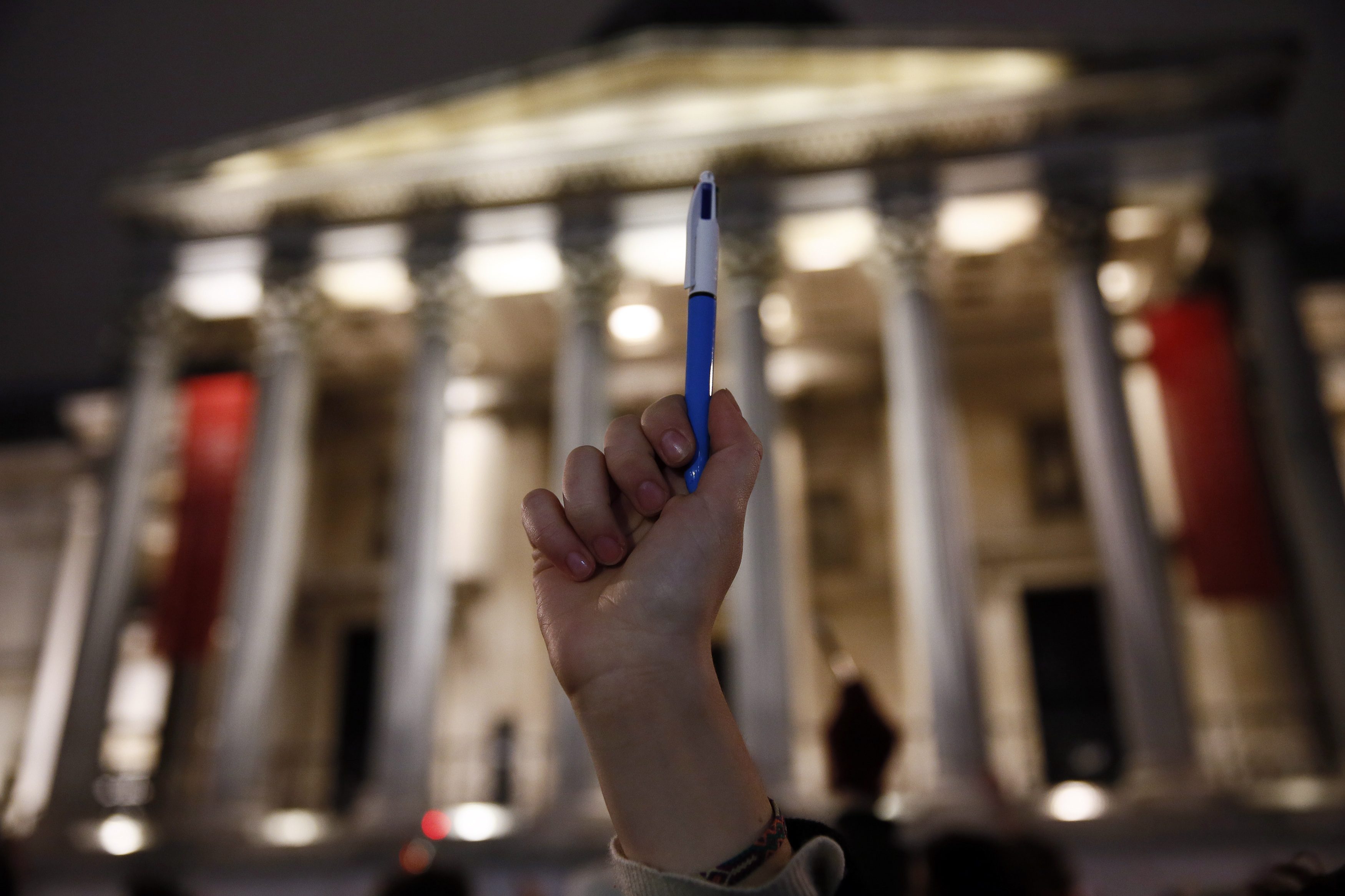 A woman raises a pen during a vigil to pay tribute to the victims of a shooting by gunmen at the offices of weekly satirical magazine Charlie Hebdo in Paris, at Trafalgar Square in London January 7, 2015. Hooded gunmen stormed the Paris offices of the weekly satirical magazine known for lampooning Islam and other religions, shooting dead at least 12 people, including two police officers, in the worst militant attack on French soil in decades. REUTERS/Stefan Wermuth (BRITAIN - Tags: POLITICS CRIME LAW CIVIL UNREST MEDIA)