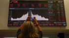 A woman takes a picture of a display showing the Swiss franc's exchange rate against the Euro and other currencies at the Swi