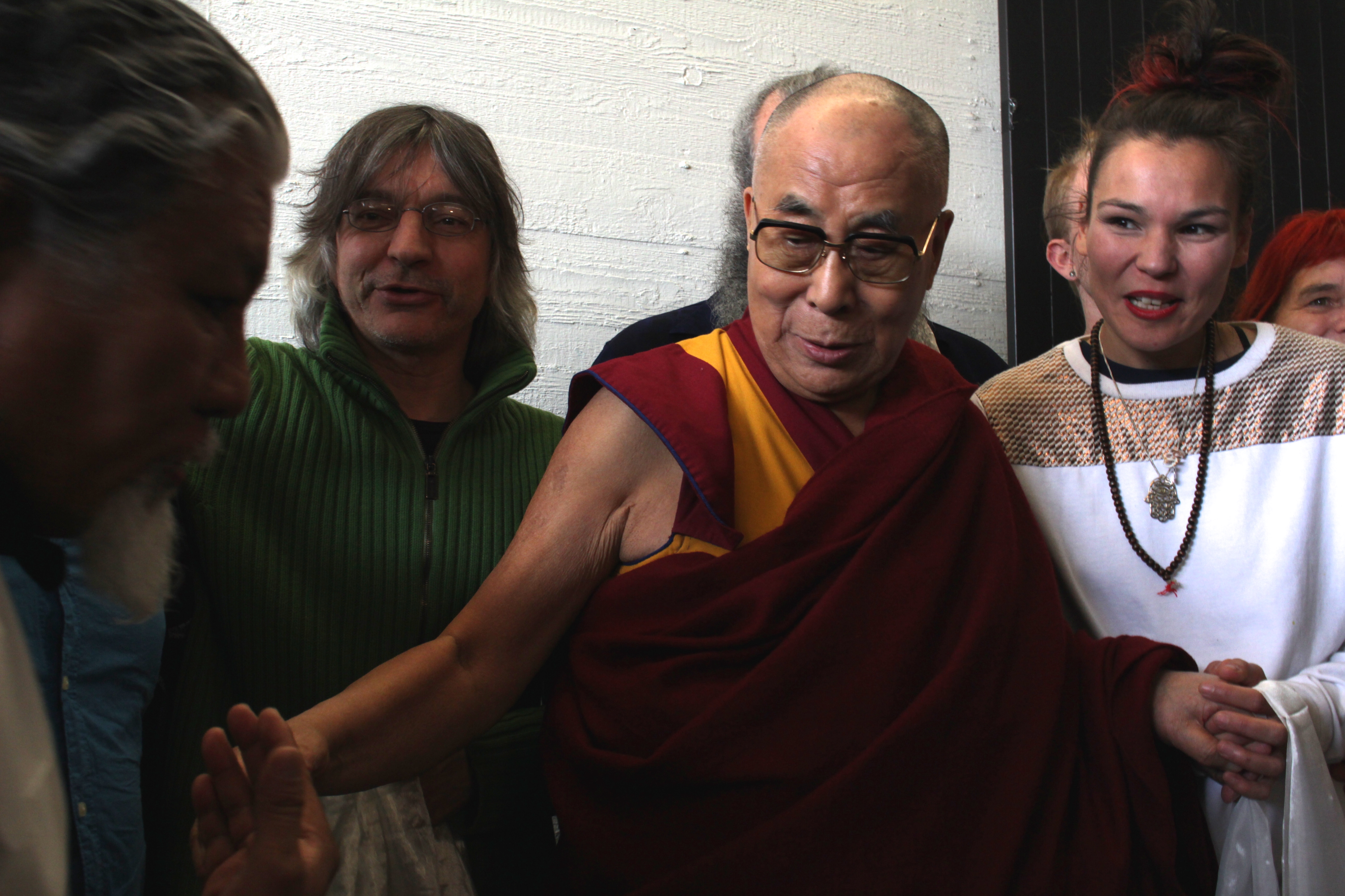 Loten Namling, Franz Treichler und Kate Wax posieren gemeinsam mit dem Dalai Lama für ein Erinnerungsfoto.