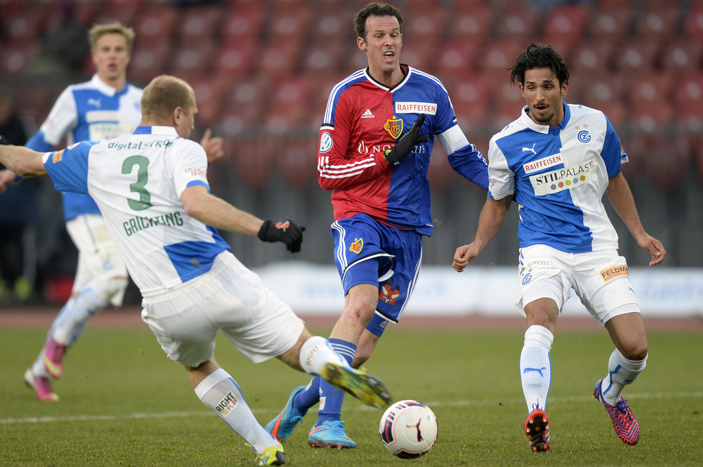 Die Zuercher Stephane Grichting, links, und Levent Guelen, rechts, gegen den Basler Marco Streller, Mitte, beim Fussball Meisterschaftsspiel der Super League zwischen dem Grasshopper Club Zuerich und dem FC Basel, am Sonntag, 8. Februar 2015, im Letzigrund Stadion in Zuerich. (KEYSTONE/Walter Bieri)