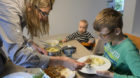 A nine-year-old boy and his 6 month old baby brother are having lunch with their mother during the school lunch break, captur