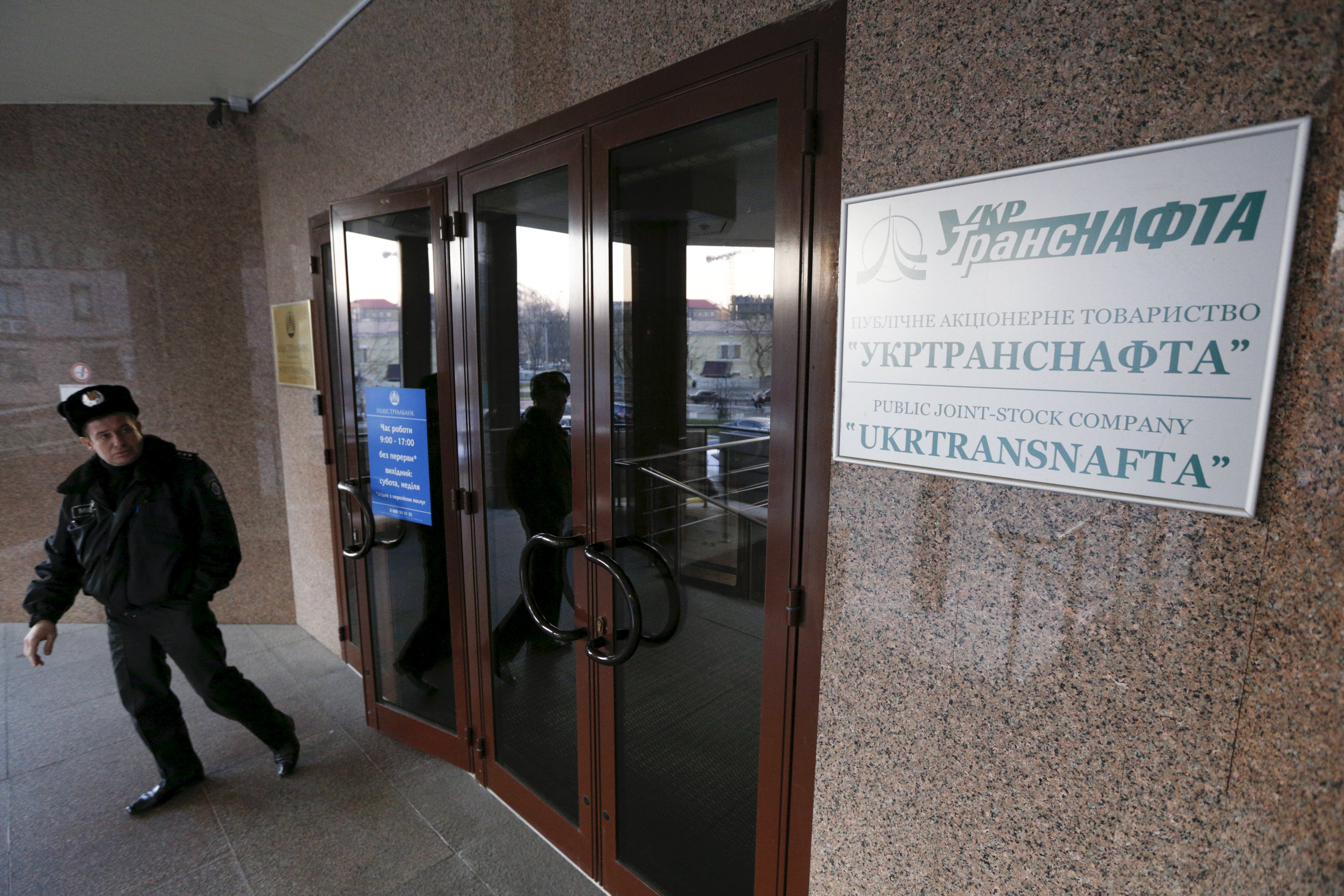 A policeman stands next to an entrance to the head office of Public Joint-Stock Company UkrTransNafta in Kiev March 20, 2015. A raid by a group of armed men in combat fatigues on the state-owned oil company in the Ukrainian capital Kiev caused uproar in parliament on Friday and thrust banking billionaire Ihor Kolomoisky into the spotlight. Two parliamentary deputies accused Kolomoisky of sending the masked men into the offices of UkrTransNafta late on Thursday night after it was announced that its chairman, an ally of the 52-year-old oligarch, had been sacked. REUTERS/Valentyn Ogirenko
