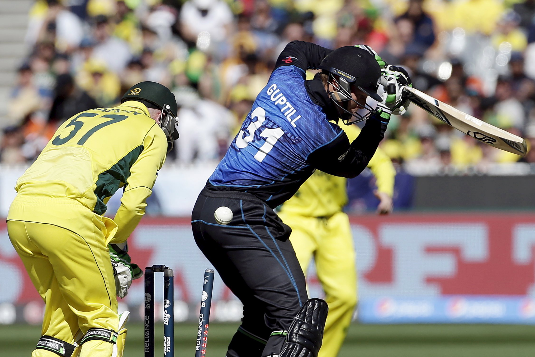 Australia's wicketkeeper Brad Haddin (L) watches as New Zealand's Martin Guptill (R) is bowled by Australia's Glenn Maxwell for 15 runs during their Cricket World Cup final match at the Melbourne Cricket Ground (MCG) March 29, 2015. REUTERS/Hamish Blair