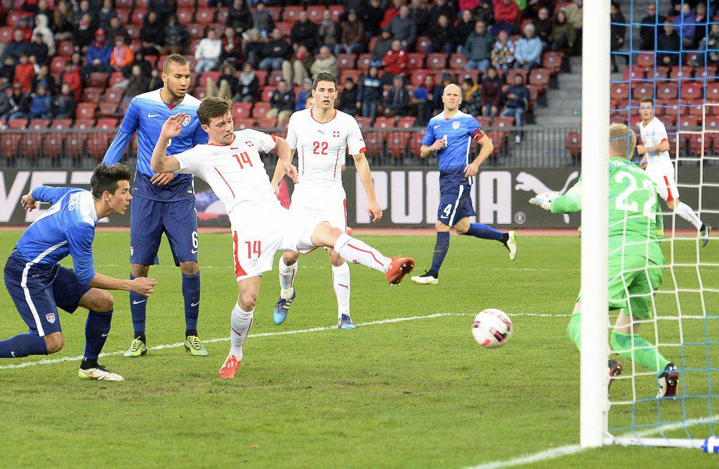 epa04687966 Switzerland's Valentin Stocker (C) scores the 1-1 equalizer against US goalkeeper William Yarbrough (R) during the international friendly soccer match between Switzerland and the USA at the Letzigrund stadium in Zurich, Switzerland, 31 March 2015. EPA/WALTER BIERI