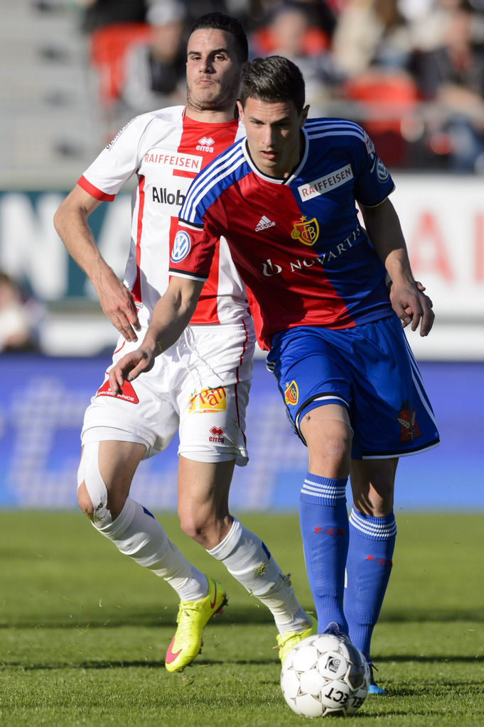 Le joueur valaisan Daniel Follonier, gauche, lutte pour le ballon avec le joueur balois Fabian Schaer, droite, lors de la rencontre de football de Super League entre le FC Sion et le FC Bale 1893, ce samedi 18 avril 2015 au stade de Tourbillon a Sion. (KEYSTONE/Laurent Gillieron)