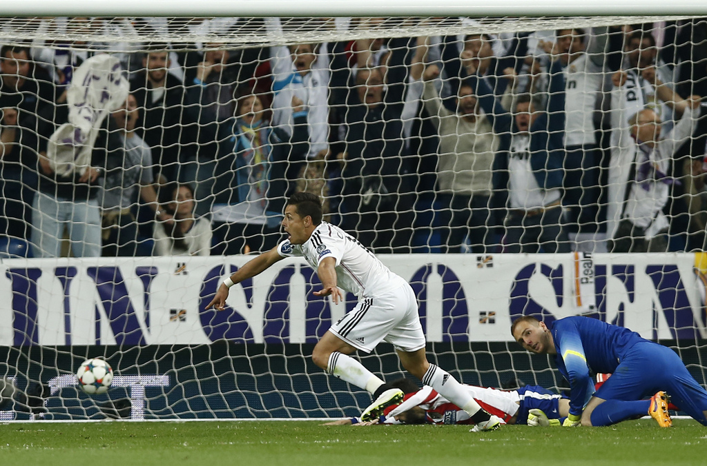 Real Madrid's Chicharito, left, runs celebrating after scoring the game's only goal past Atletico goalkeeper Jan Oblak, right, during the second leg quarterfinal Champions League soccer match between Real Madrid and Atletico Madrid at Santiago Bernabeu stadium in Madrid, Spain, Wednesday, April 22, 2015. (AP Photo/Andres Kudacki)