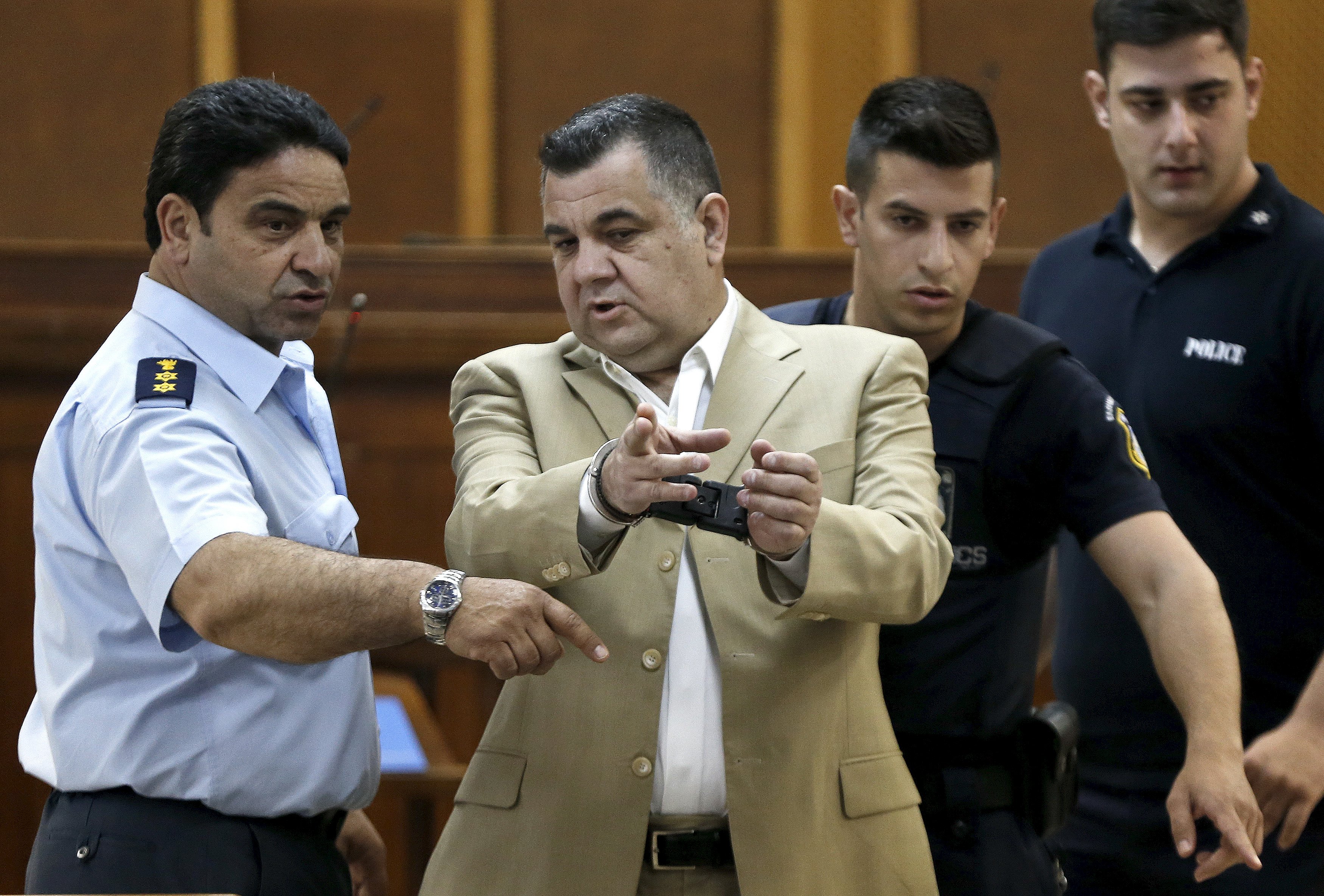 Giorgos Roupakias (C), who is in custody pending trial over the killing of anti-racism Greek rapper Pavlos Fissas, is escorted by police officers at the court room where the trial of members and leaders of Greece's far-right Golden Dawn party takes place, in Koridallos prison, near Athens, May 7, 2015. Party leader Nikos Mihaloliakos and more than a dozen top figures in Golden Dawn were arrested on charges of founding and participating in a criminal organisation following the killing of an anti-fascism rapper in 2013 by a party supporter. REUTERS/Alkis Konstantinidis