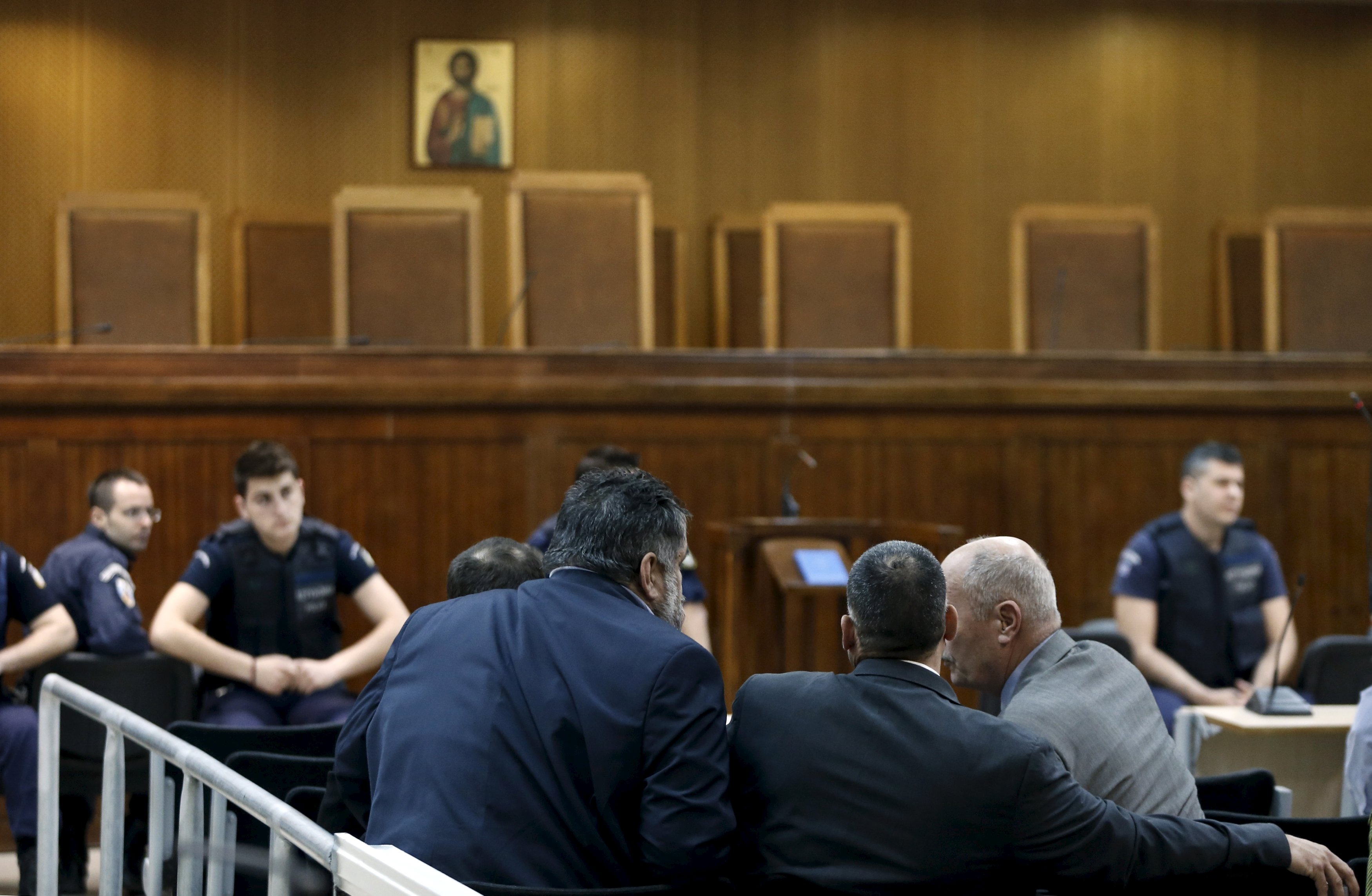 Far-right Golden Dawn party lawmakers Mihalis Arvanitis (R), Polivios Zisimopoulos (C) and Dimitris Koukoutsis, who face charges of forming a criminal gang, discuss in a courtroom where the trial of members and leaders of the party takes place, in Koridallos prison, near Athens, May 12, 2015. Party leader Nikos Mihaloliakos and more than a dozen top figures in Golden Dawn were arrested on charges of founding and participating in a criminal organisation following the killing of anti-racism rapper Pavlos Fissas in 2013 by a party supporter. REUTERS/Alkis Konstantinidis