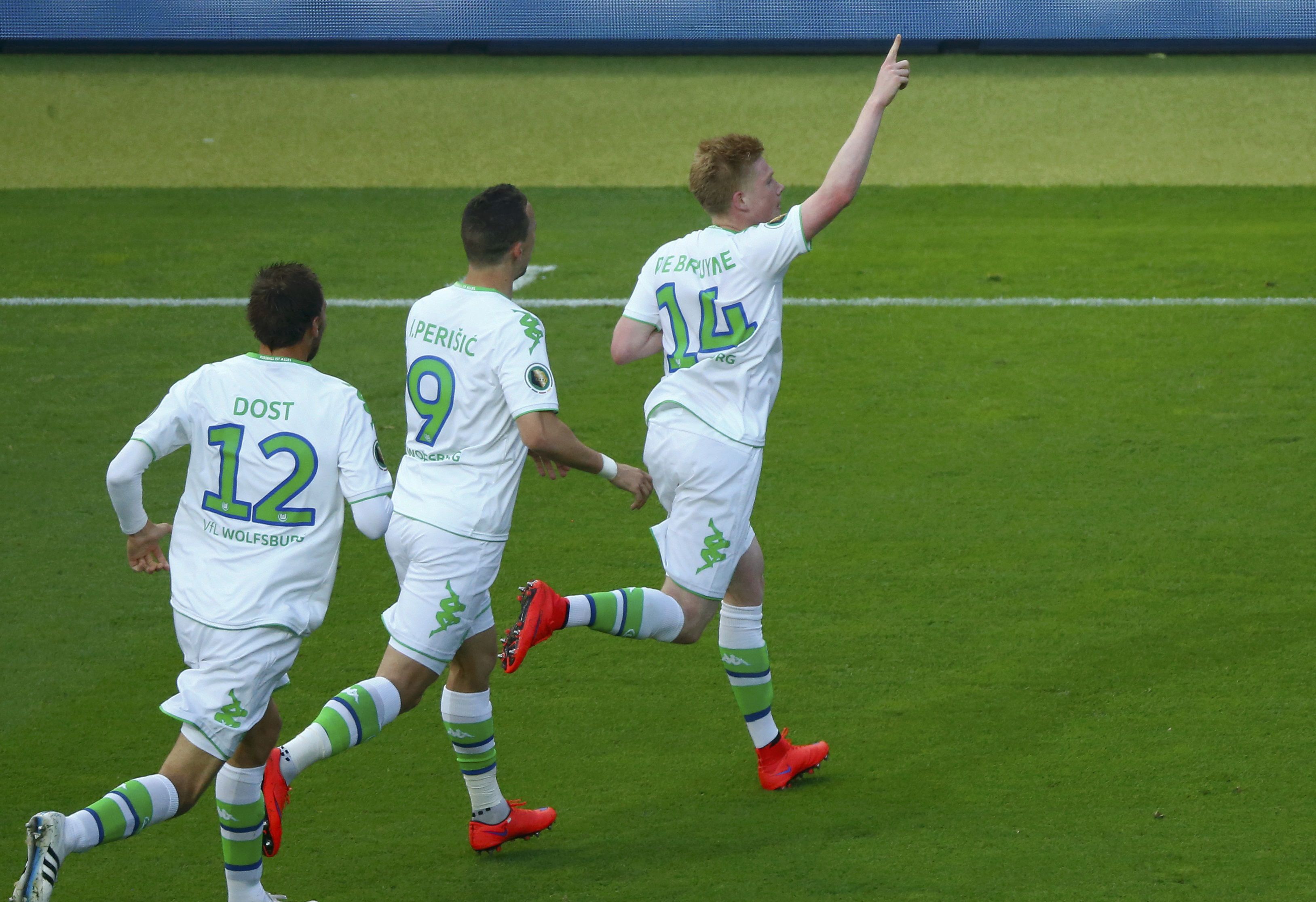 VfL Wolfsburg's Bas Dost (L) and Ivan Perisic celebrate after Kevin De Bruyne (R) scored a goal against Borussia Dortmund during their German Cup (DFB Pokal) final soccer match in Berlin, Germany, May 30, 2015. REUTERS/Hannibal Hanschke DFB RULES PROHIBIT USE IN MMS SERVICES VIA HANDHELD DEVICES UNTIL TWO HOURS AFTER A MATCH AND ANY USAGE ON INTERNET OR ONLINE MEDIA SIMULATING VIDEO FOOTAGE DURING THE MATCH.