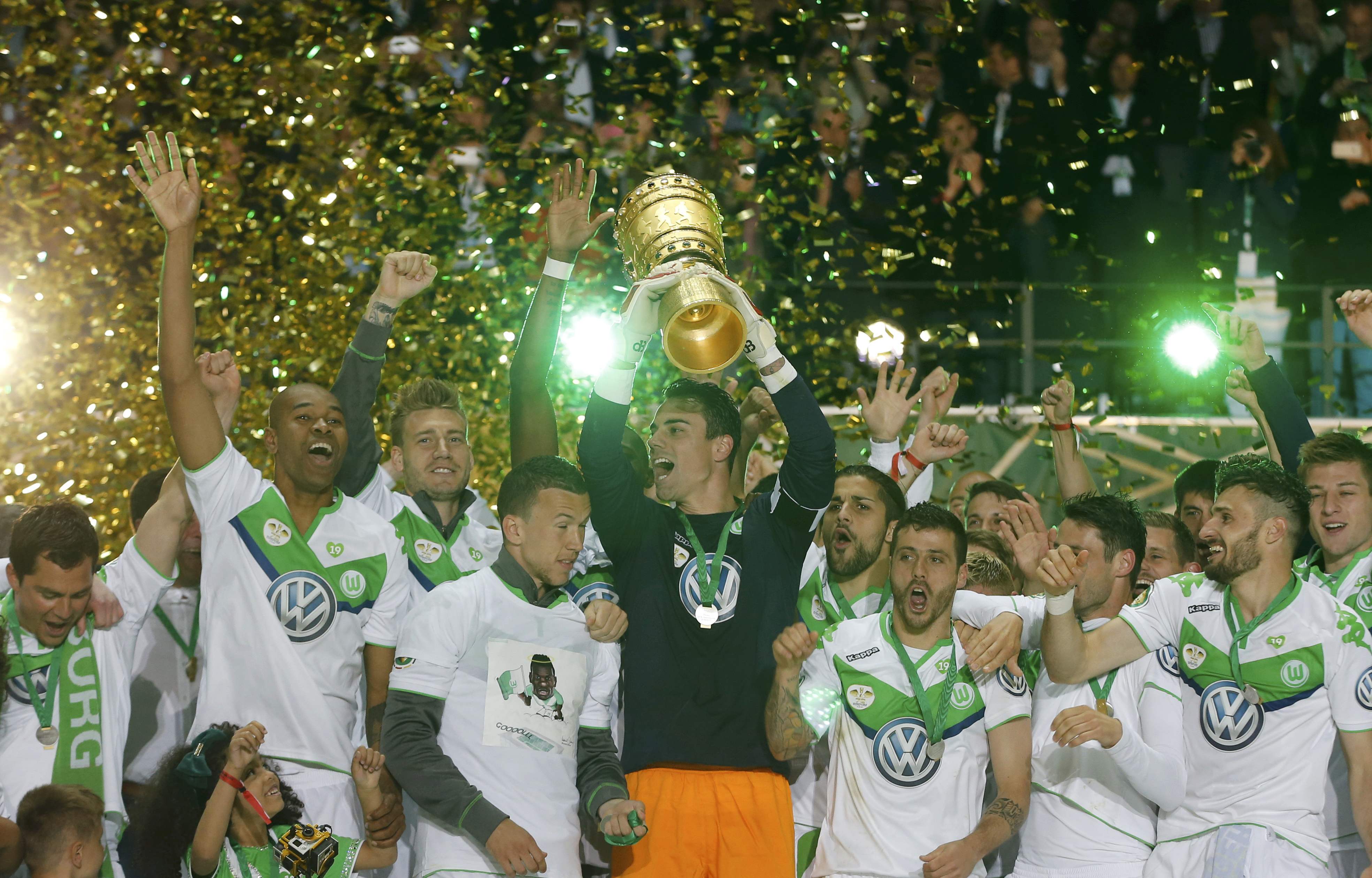 Diego Benaglio, der Schweizer Captain des VfL Wolfsburg, stemmt die Trophäe in den Berliner Nachthimmel.