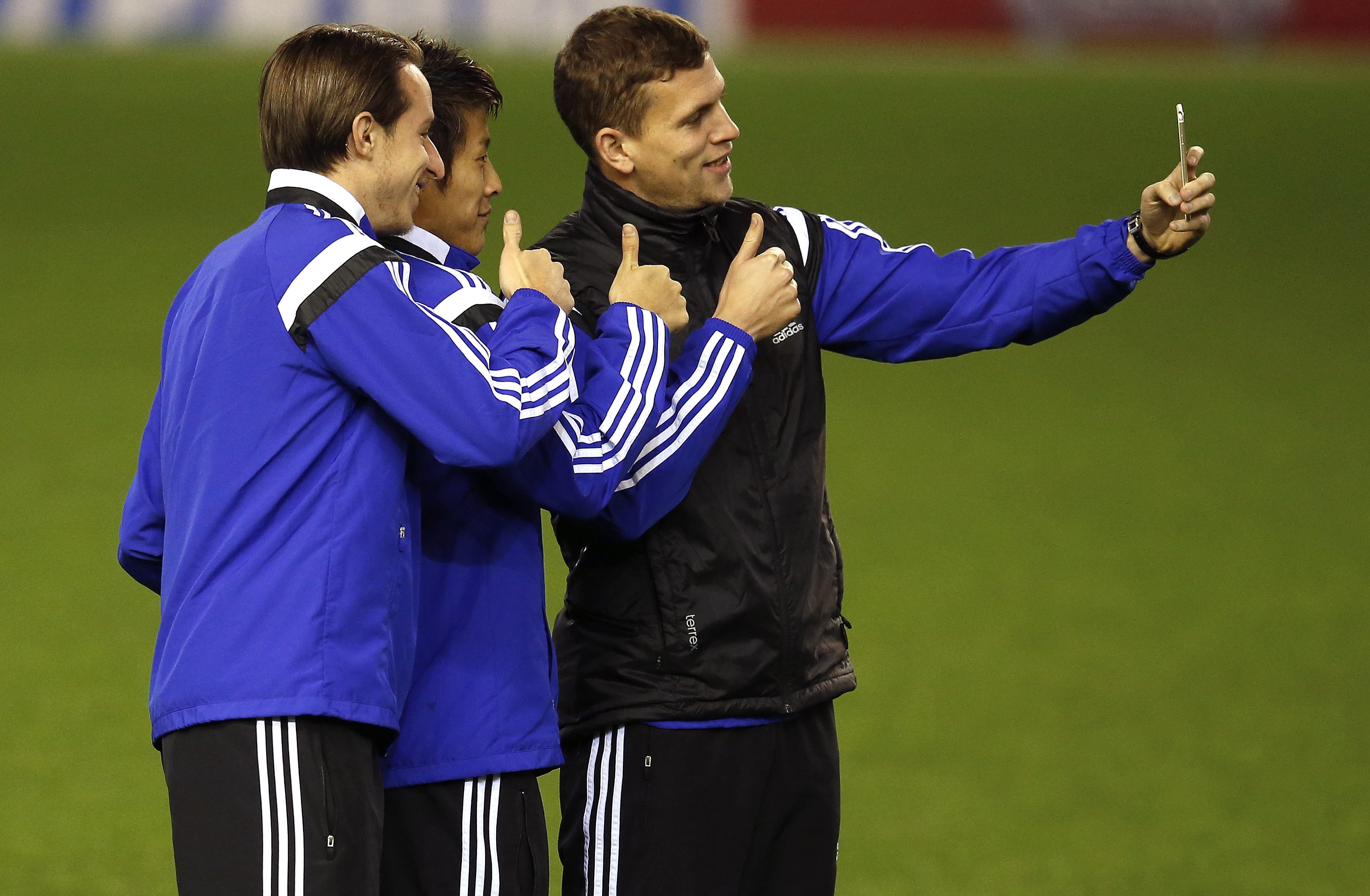 FC Basel's (L-R) Luca Zuffi, Yoichiro Kakitani and Fabian Frei pose for a photograph before a training session at Anfield in Liverpool, northern England December 8, 2014. FC Basel are set to play Liverpool in the Champions League on Tuesday. REUTERS/Phil Noble (BRITAIN - Tags: SPORT SOCCER)