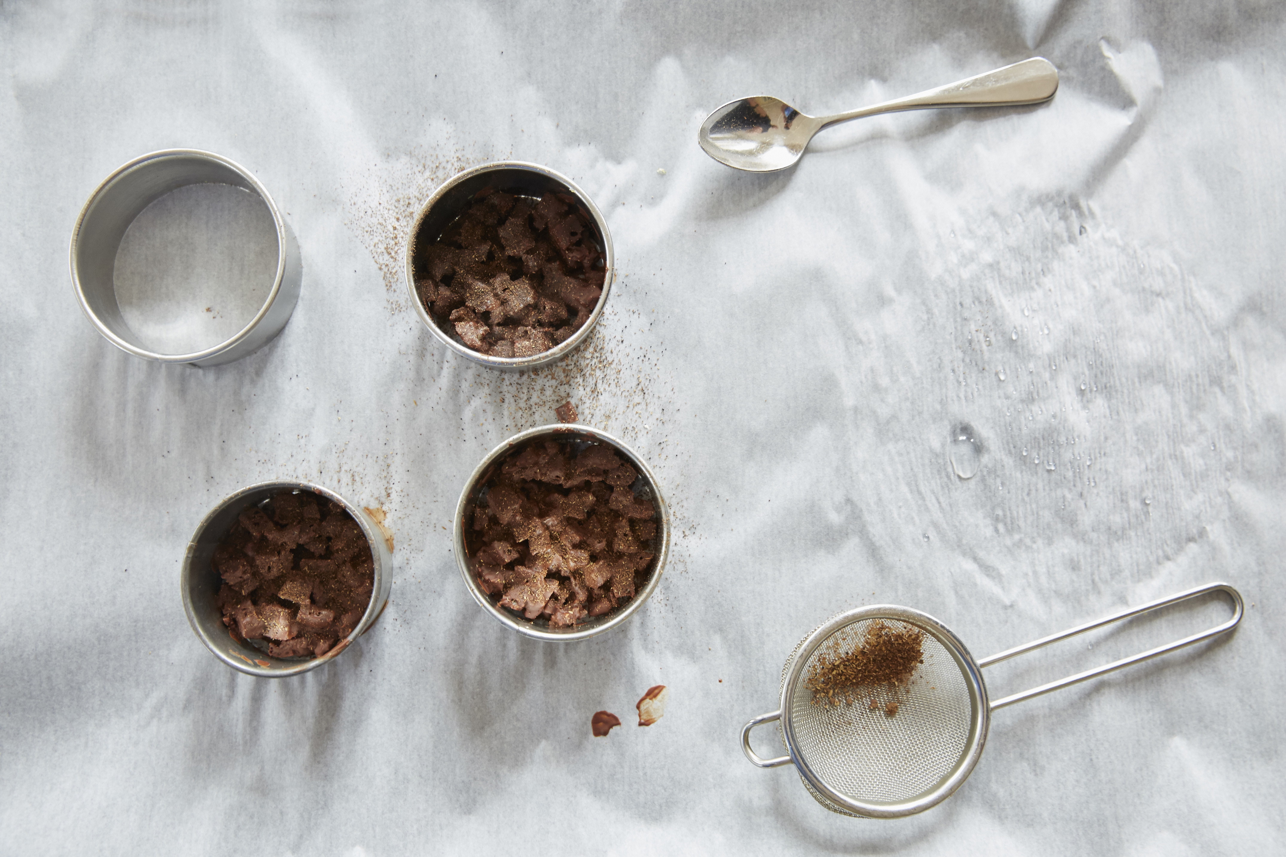 Das Schokoladen-Crumble wird mit Szechuan-Pfeffer oder einem Gewürz nach eigenem Gusto bepudert.