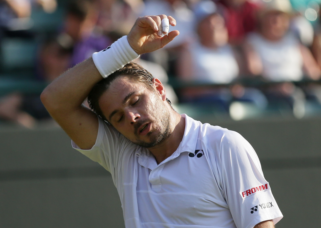 Stan Wawrinka of Switzerland wipes his head as he plays Victor Estrella Burgos of the Dominican Republic during their singles match at the All England Lawn Tennis Championships in Wimbledon, London, Wednesday July 1, 2015. (AP Photo/Tim Ireland)