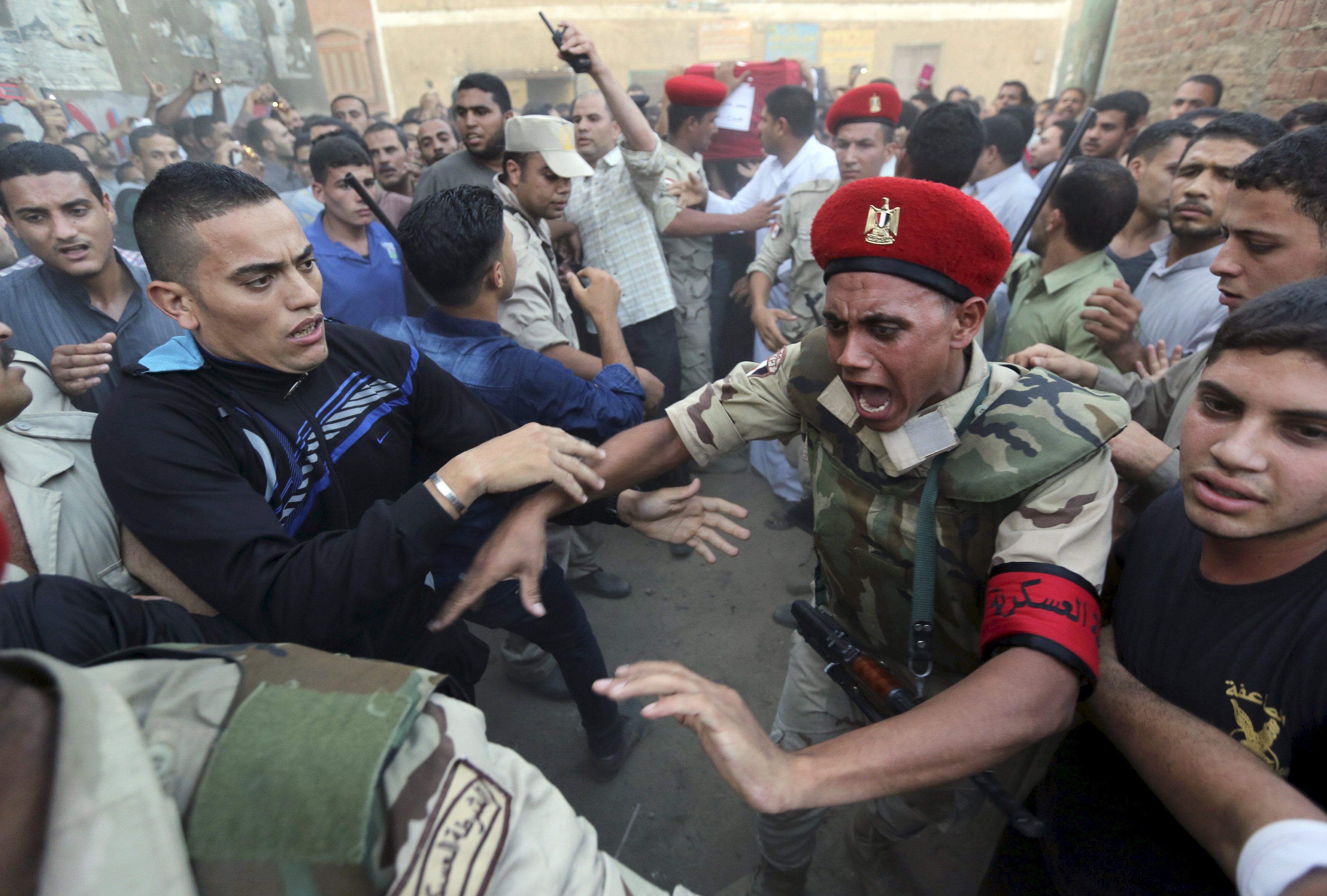 Military policemen try to open a path ahead for the funeral of 21-year-old Mohamed Adel, one of the army officers who died in yesterday's Sinai attacks, in Al-Kaliobeya, near Cairo, Egypt, July 2, 2015. Egypt launched air strikes on Islamist militant targets in the Sinai peninsula on Thursday, killing 23 fighters a day after the deadliest clashes in the region in years, security sources said. The sources said those killed had taken part in Wednesday's fighting in which 100 militants and 17 soldiers, including four officers, were killed, according to the army spokesman. REUTERS/Mohamed Abd El Ghany TPX IMAGES OF THE DAY