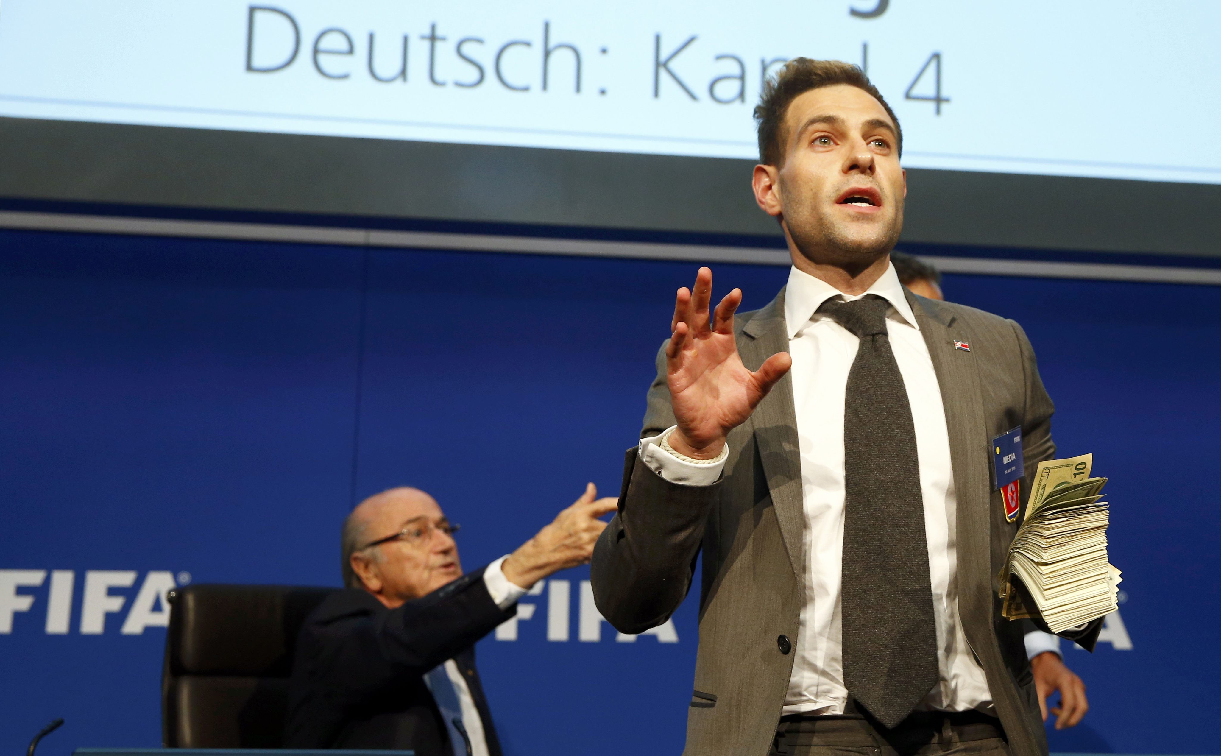 British comedian known as Lee Nelson holds banknotes in front of FIFA President Sepp Blatter (L) at a news conference after the Extraordinary FIFA Executive Committee Meeting at the FIFA headquarters in Zurich, Switzerland July 20, 2015. World football's troubled governing body FIFA will vote for a new president, to replace Sepp Blatter, at a special congress to be held on February 26 in Zurich, the organisation said on Monday. REUTERS/Arnd Wiegmann