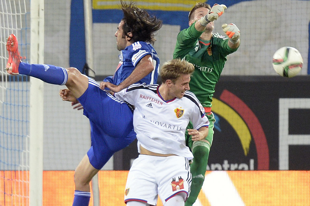 Der Luzerner Dario Lezcano, links, gegen die Basler Daniel Hoegh, Mitte, und Tomas Vaclik, rechts, beim Fussball Meisterschaftsspiel der Super League zwischen dem FC Luzern und dem FC Basel am Samstag, 8. August 2015, in der Swissporarena in Luzern. (KEYSTONE/Walter Bieri)
