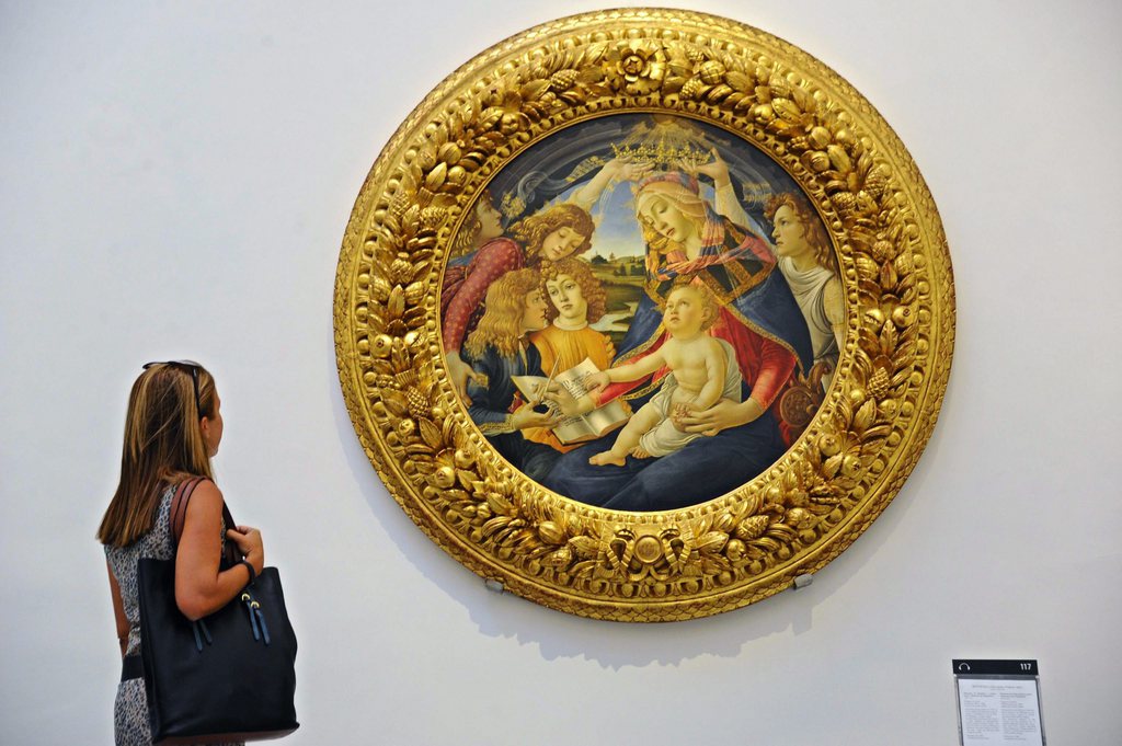 epa04845422 A visitor looks at the painting 'Madonna of the Magnificat' by Italian Renaissance artist Sandro Botticelli displayed at the room 'Sala 21' at Galleria degli Uffizi in Florence, Italy, 13 July 2015. Masterpieces of Botticelli, Pollaiuolo and the Portinari Triptych have been transferred to the room 21 of the Gallery. EPA/MAURIZIO DEGL' INNOCENTI