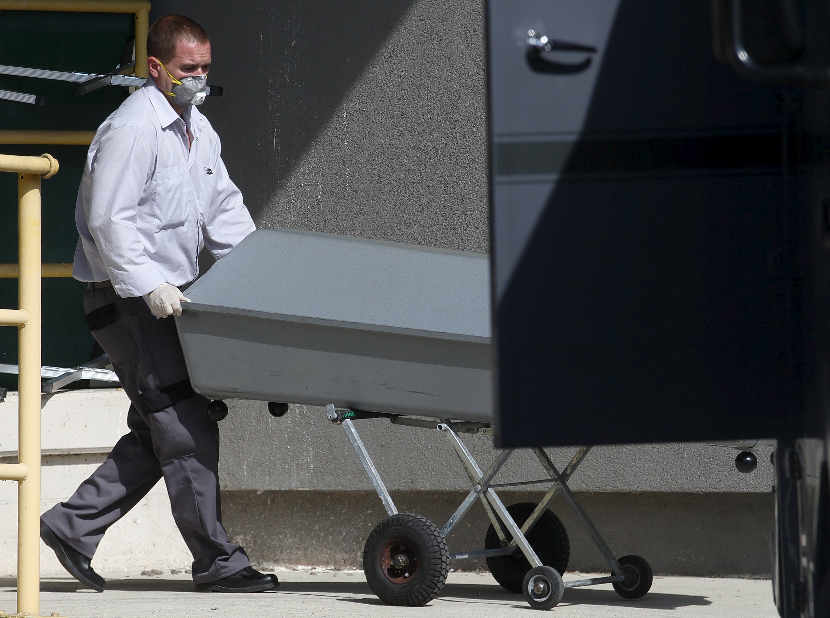 A coffin is rolled onto a truck at a customs building with refrigeration facilities in the village of Nickelsdorf, Austria, August 28, 2015. A truck full of refugees discovered abandoned on an Austrian motorway on Thursday contains more than 70 bodies, the interior ministry said on Friday, announcing an updated death toll. REUTERS/Heinz-Peter Bader