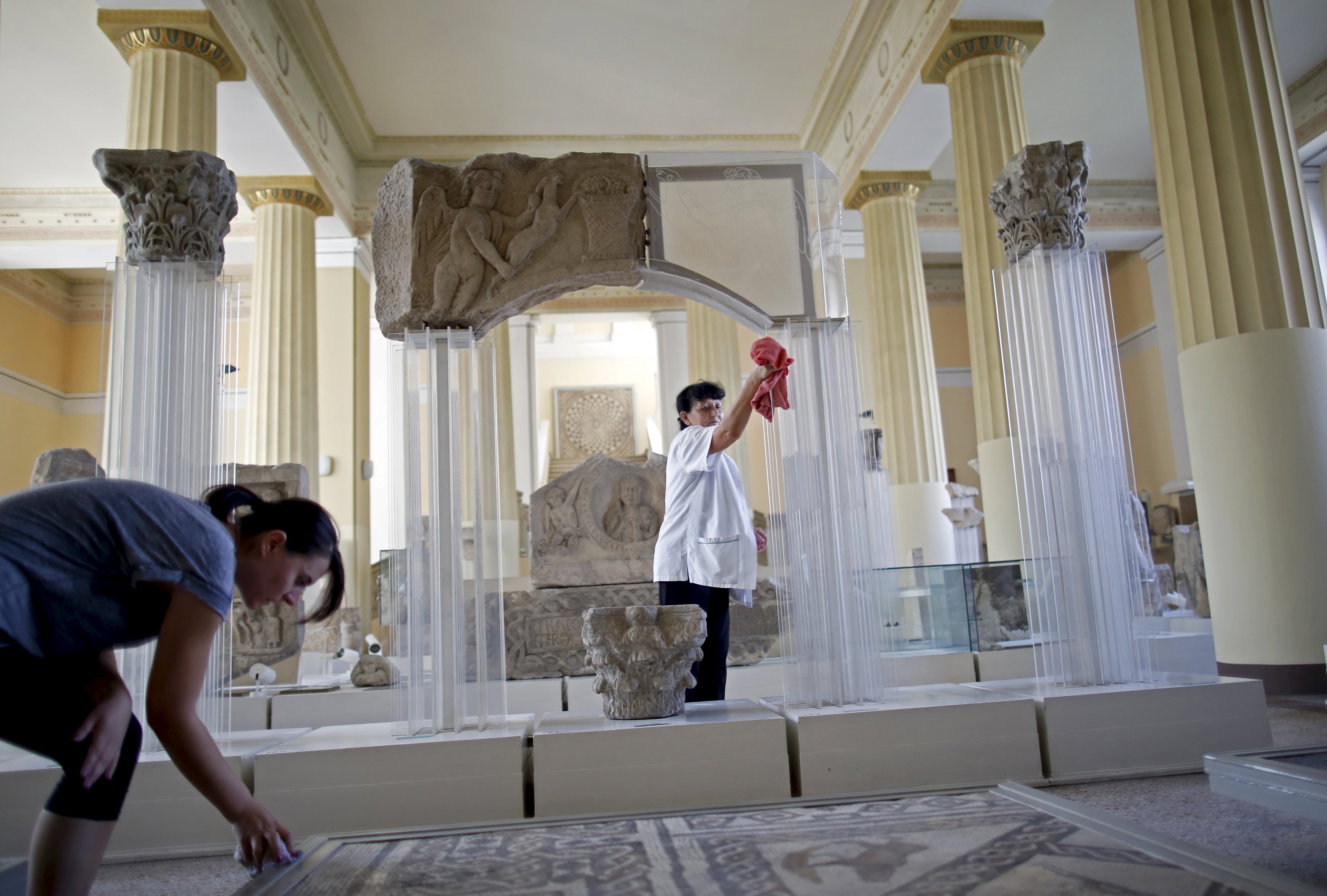 National Museum employees Ana Maric (L) and Djula Keric clean archaeological excavations in National Museum in Sarajevo, September 9, 2015. Employees at Bosnia's National Museum, known as the British Museum of the Balkans, returned to work on Wednesday to prepare for the re-opening of the institution which was closed three years ago over a lack of funding. The divided country's authorities have promised to provide funding for the Sarajevo landmark museum and open it on Sept. 15, following years of failed attempts to agree on how to finance it. REUTERS/Dado Ruvic
